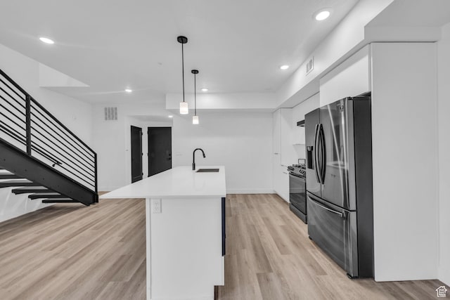 933 S Washington St Unit 107, Salt Lake City, UT 84101 - kitchen featuring black range oven, stainless steel fridge with ice dispenser, white cabinets, visible vents, and a sink