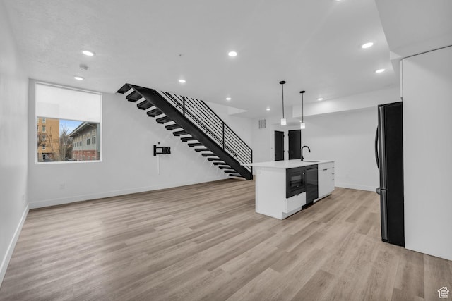 933 S Washington St Unit 107, Salt Lake City, UT 84101 - kitchen featuring open floor plan, light wood finished floors, light countertops, and black appliances