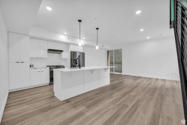 933 S Washington St Unit 107, Salt Lake City, UT 84101 - kitchen featuring white cabinets, under cabinet range hood, modern cabinets, stainless steel appliances, and a sink
