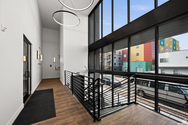 933 S Washington St Unit 107, Salt Lake City, UT 84101 - corridor with an upstairs landing, a high ceiling, baseboards, and wood finished floors