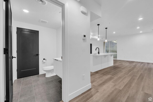 933 S Washington St Unit 107, Salt Lake City, UT 84101 - full bathroom with vanity, baseboards, toilet, visible vents, and wood finished floors
