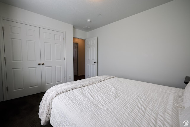 bedroom featuring dark carpet and a closet