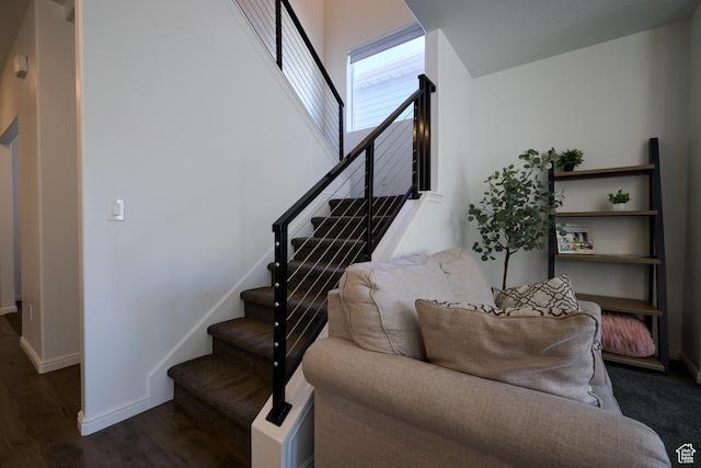 staircase with wood finished floors and baseboards