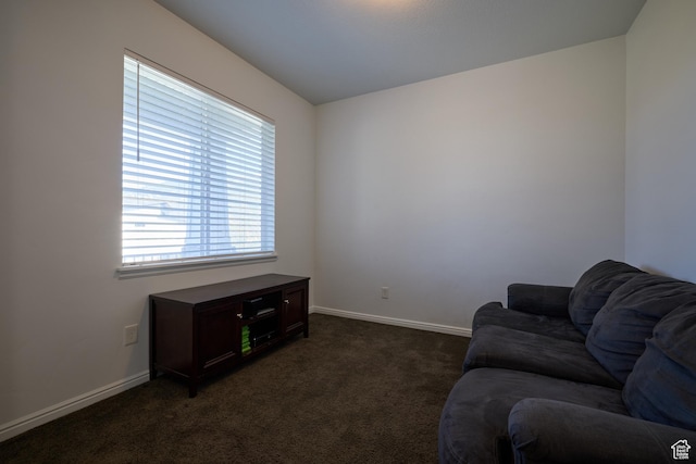 sitting room with baseboards and dark colored carpet