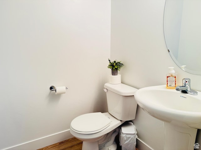 bathroom featuring baseboards, toilet, and wood finished floors
