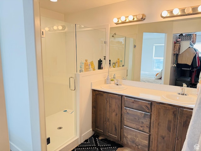 full bathroom with a stall shower, double vanity, a sink, and connected bathroom