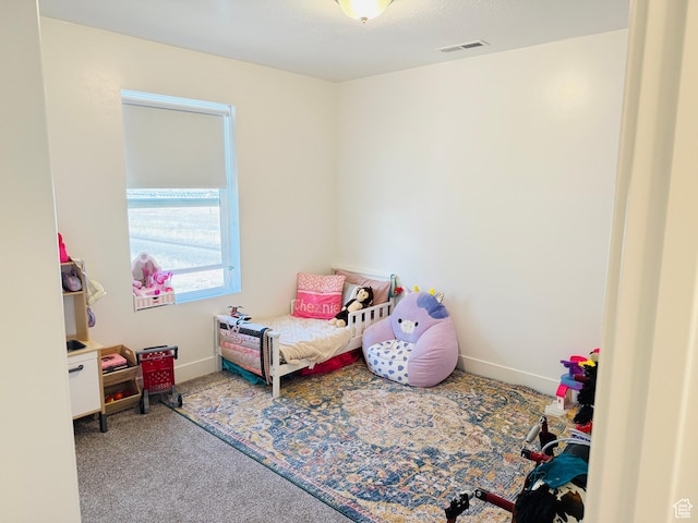 carpeted bedroom featuring visible vents and baseboards