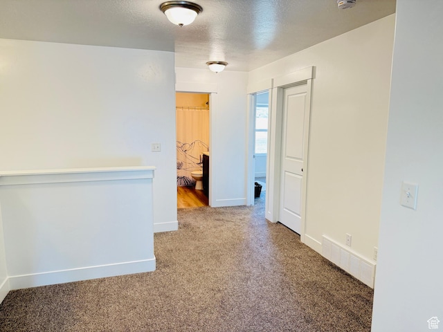 carpeted empty room featuring visible vents, baseboards, and a textured ceiling
