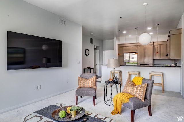 living area with visible vents, baseboards, recessed lighting, and light carpet