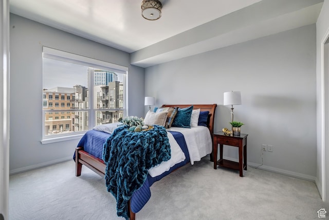 carpeted bedroom with a city view and baseboards