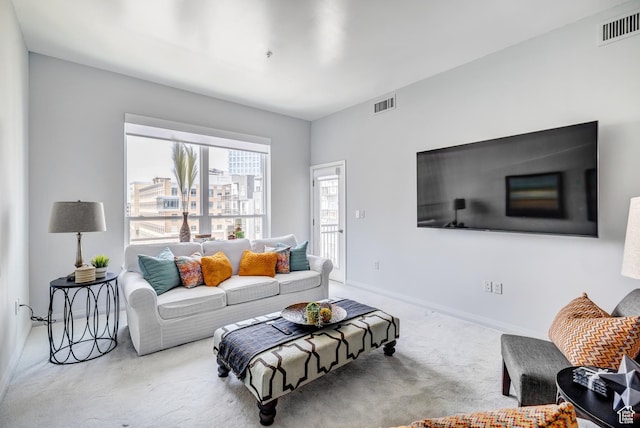 carpeted living area featuring visible vents and baseboards