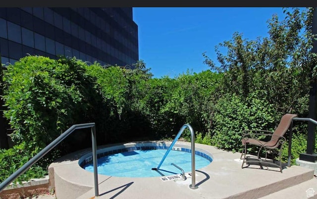 view of pool with a patio and a hot tub