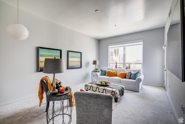 living area featuring light carpet and baseboards