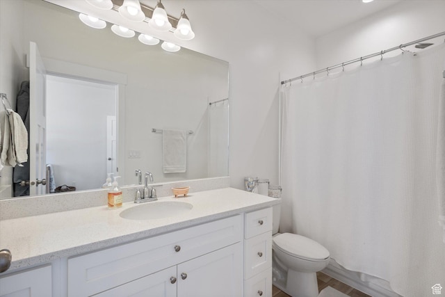 bathroom featuring toilet, curtained shower, and vanity
