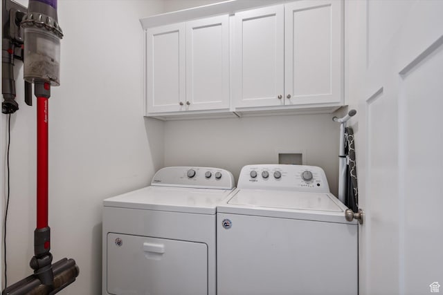 clothes washing area featuring washer and dryer and cabinet space