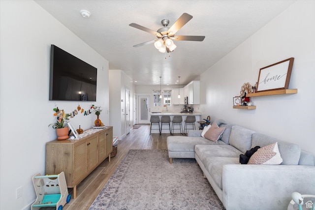 living room with light wood-style flooring and a ceiling fan