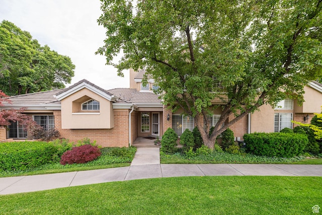 2356 E 3900 S, Millcreek, UT 84124 - view of front facade with a front lawn, brick siding, stucco siding, and a tiled roof
