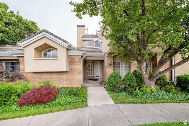 2356 E 3900 S, Millcreek, UT 84124 - view of front of home with brick siding, stucco siding, a tile roof, and a chimney