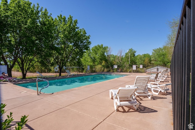 pool with a patio and fence