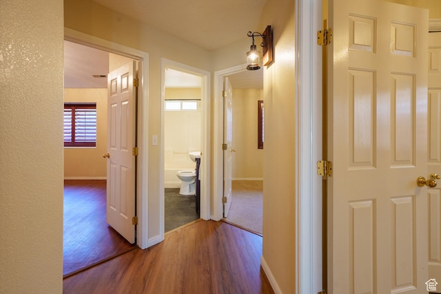 hall featuring wood finished floors and baseboards