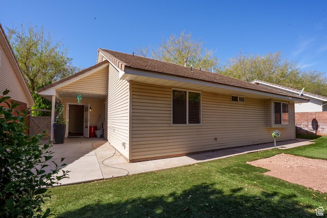 back of property with a lawn, fence, and a patio area