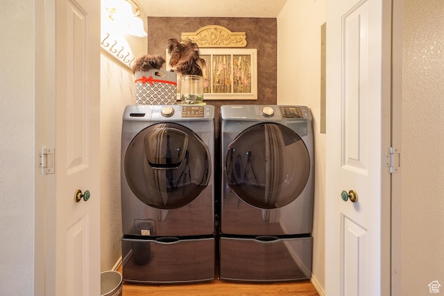 washroom with wood finished floors, laundry area, and washer and clothes dryer