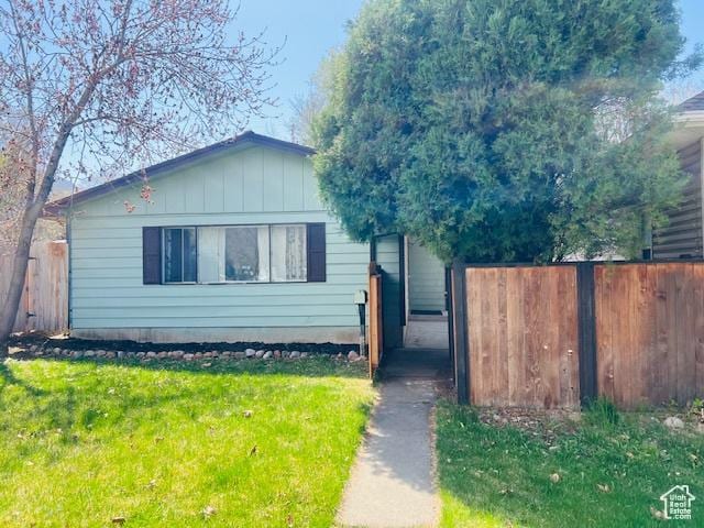 view of front of property with a front yard and fence