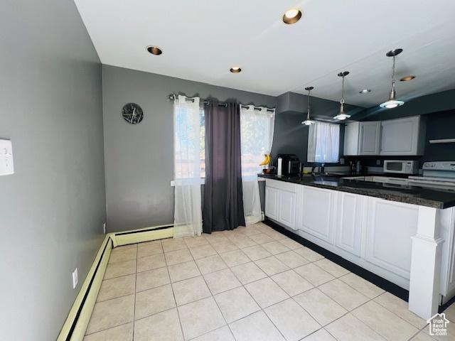 kitchen featuring hanging light fixtures, baseboard heating, light tile patterned flooring, and dark countertops