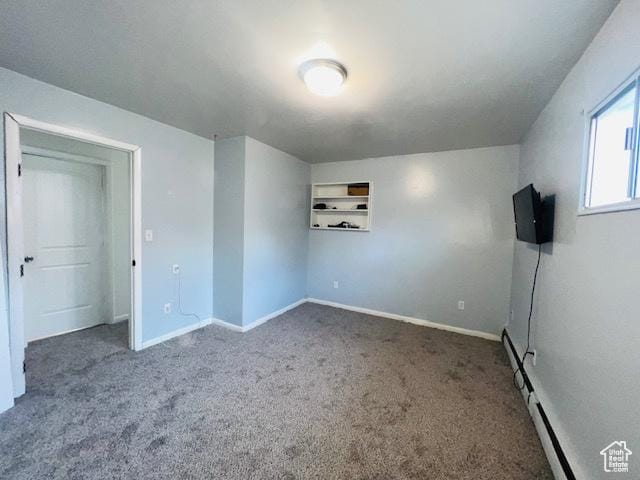 unfurnished bedroom featuring carpet, baseboard heating, and baseboards