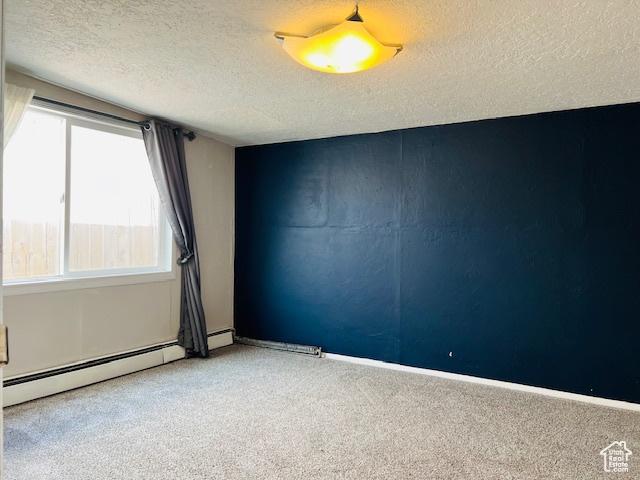 carpeted spare room with baseboard heating, a textured ceiling, and baseboards