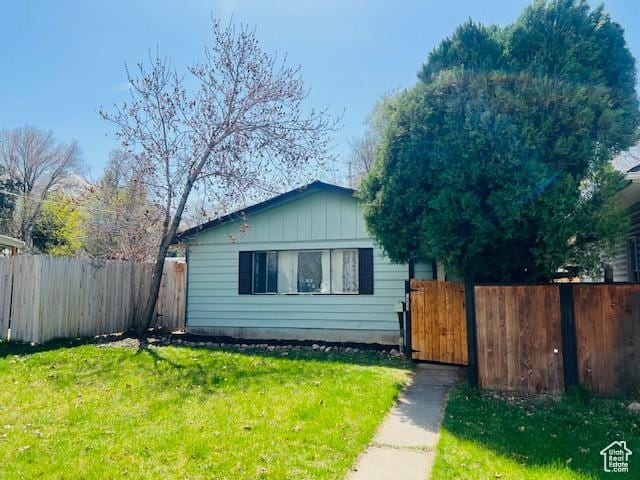 view of front of home featuring a front yard, fence, and a gate