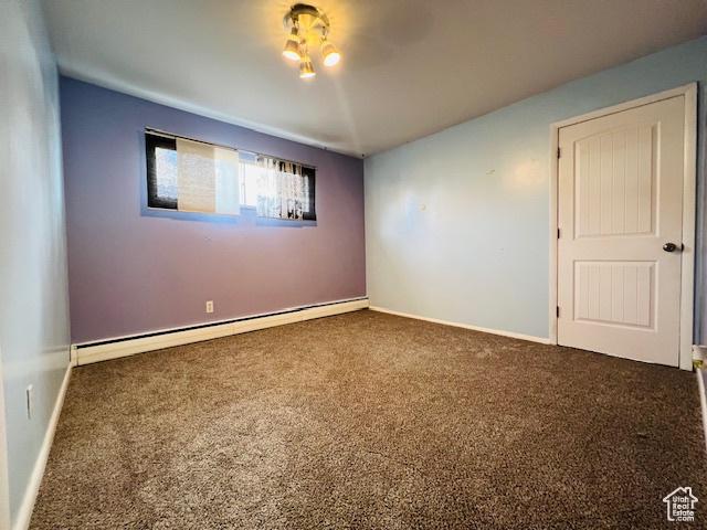 unfurnished room featuring baseboard heating, carpet flooring, and baseboards