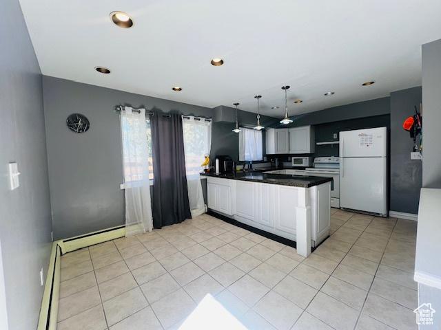 kitchen with light tile patterned floors, a peninsula, freestanding refrigerator, dark countertops, and electric stove
