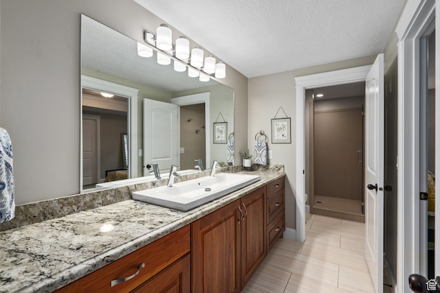 bathroom featuring tile patterned floors, vanity, a textured ceiling, and a stall shower