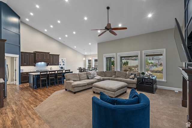 living room with high vaulted ceiling, recessed lighting, wood finished floors, and ceiling fan