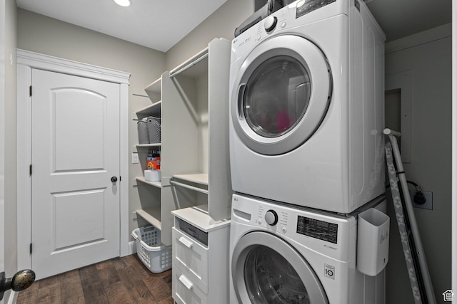 clothes washing area with laundry area, dark wood finished floors, and stacked washer / drying machine