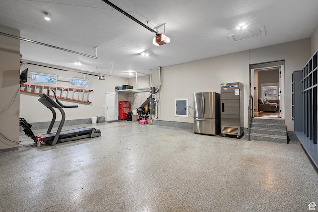 garage featuring a garage door opener and freestanding refrigerator