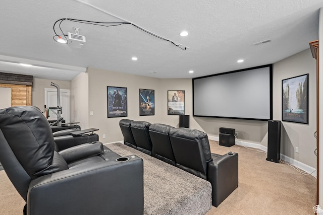 cinema room featuring visible vents, baseboards, light colored carpet, and a textured ceiling