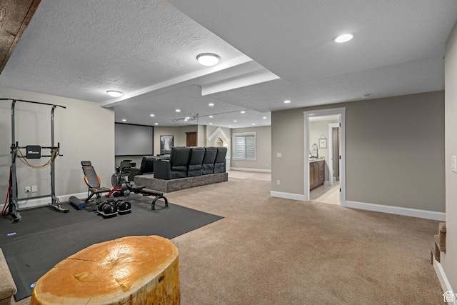 exercise room featuring baseboards, recessed lighting, light carpet, and a textured ceiling