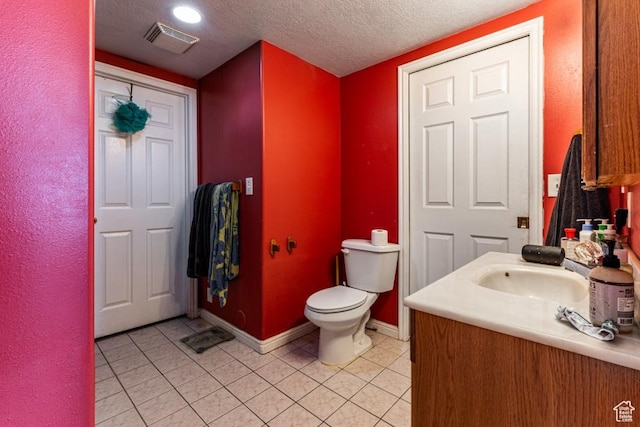 bathroom with tile patterned floors, visible vents, and a textured ceiling