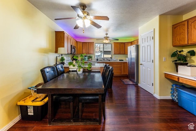 dining space featuring dark wood finished floors, a textured ceiling, baseboards, and ceiling fan