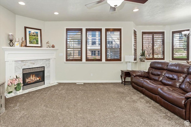 living area featuring recessed lighting, carpet, a premium fireplace, baseboards, and ceiling fan