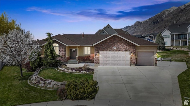 view of front facade featuring a garage, a front lawn, stone siding, and concrete driveway