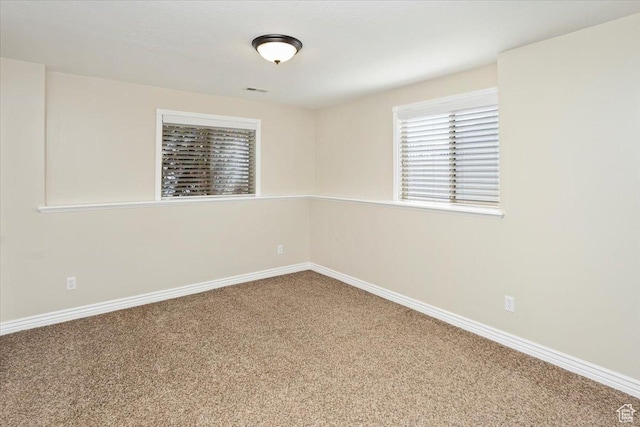 carpeted empty room featuring baseboards