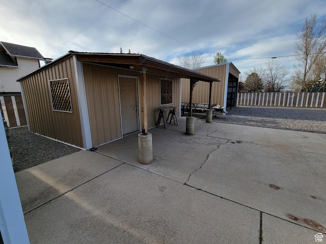 exterior space featuring fence and an outbuilding