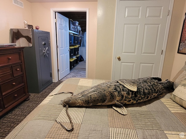 bedroom with a walk in closet, a closet, carpet floors, and visible vents