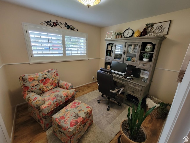 home office with baseboards and wood finished floors
