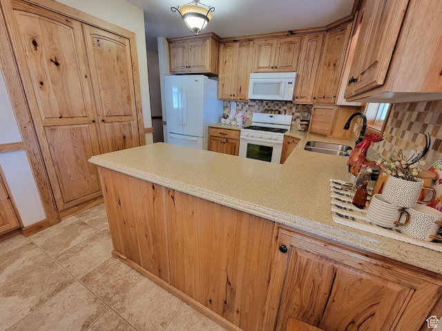 kitchen with light stone counters, a sink, white appliances, decorative backsplash, and a peninsula