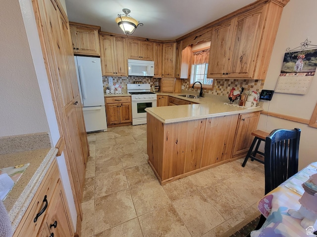 kitchen with decorative backsplash, light countertops, white appliances, and a peninsula