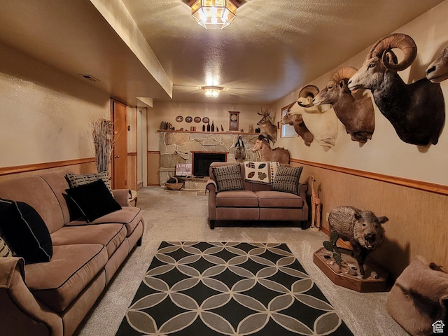 carpeted living area featuring a textured ceiling, visible vents, and a fireplace